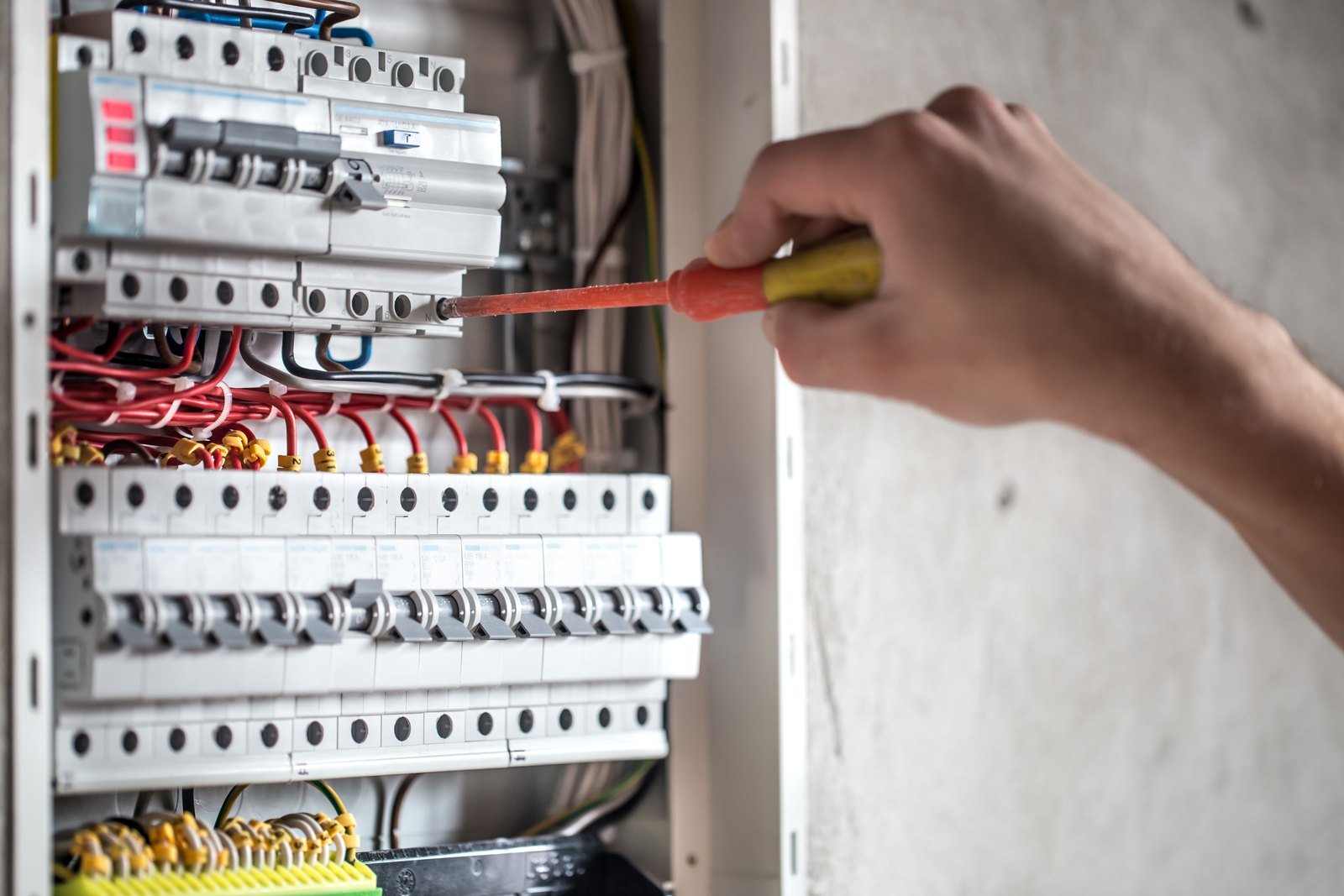Técnico trabalhando em um painel elétrico aberto
